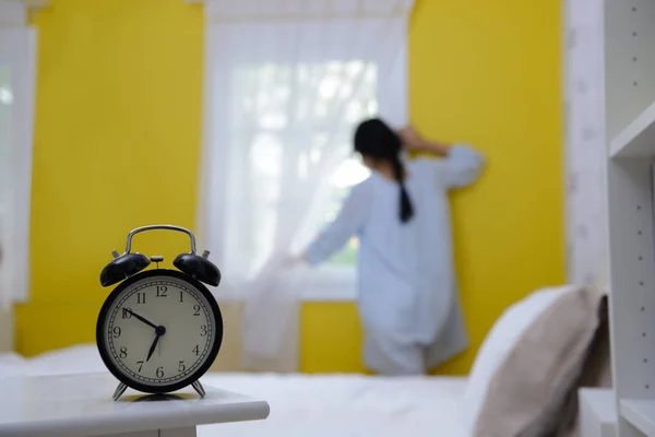 Donna al mattino guardando l'alba in piedi vicino alla finestra in camera da letto — Foto Stock