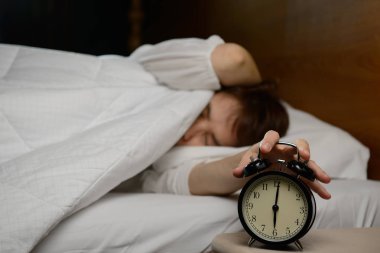 Kadın yatakta çalar saat devre dışı bırakarak