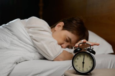 Kadın yatakta çalar saat devre dışı bırakarak