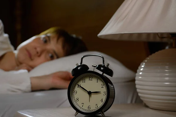 Uykusuzluk çeken bir kadın açık gözlerle yatakta yatıyor. — Stok fotoğraf