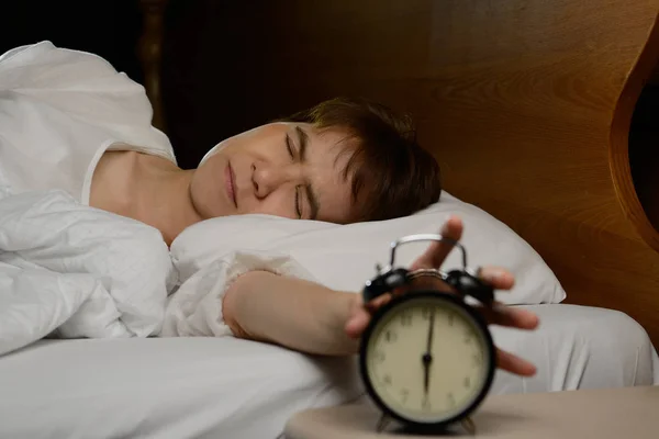 Kadın yatakta çalar saat devre dışı bırakarak — Stok fotoğraf