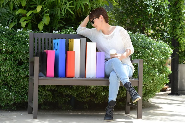 Mulher relaxante no banco fora shopping center — Fotografia de Stock