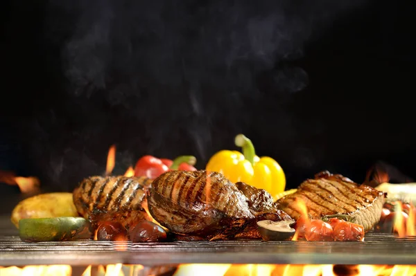 Carne a la parrilla / bistec con verduras en la parrilla en llamas —  Fotos de Stock