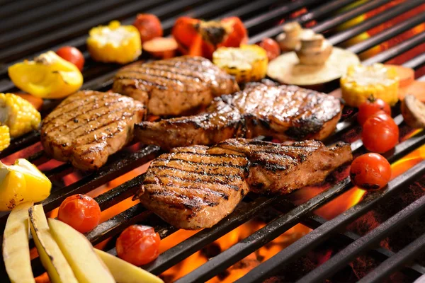 /Steak grilované maso se zeleninou na hořící grilu — Stock fotografie