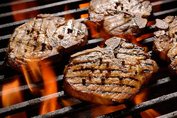 Grillet svinekød bøf på den flammende grill - Stock-foto