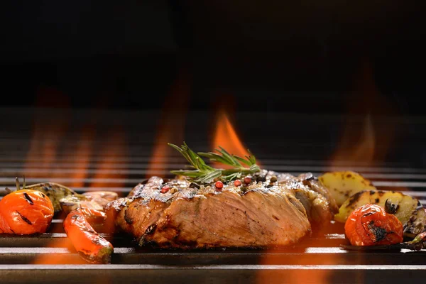 Grillet svinekød bøf med grøntsager på den flammende grill - Stock-foto