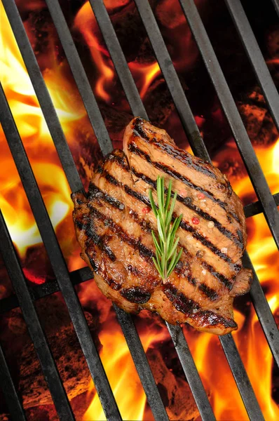 Grilled pork steak on the flaming grill — Stock Photo, Image