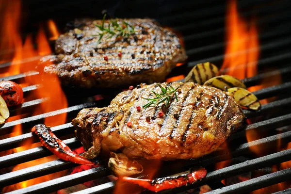 Grilled pork steak with vegetable on the flaming grill Stock Photo