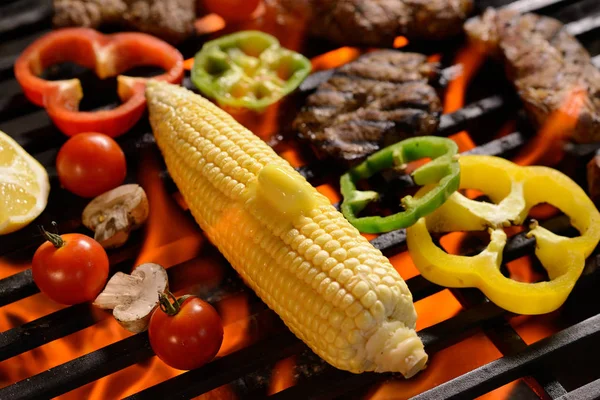Carne grelhada / bife com legumes e manteiga no topo de uma grelha flamejante — Fotografia de Stock