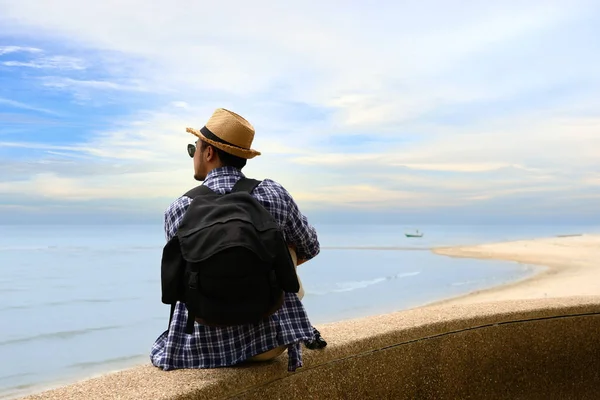 Ο άνθρωπος ταξιδιώτη με σακίδιο χαλαρώνοντας στο παραθαλάσσιο και ψάχνει να τον ωκεανό — Φωτογραφία Αρχείου