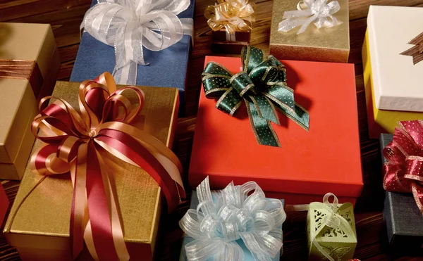 Miscela di scatole regalo sormontate da nastri su superficie in legno — Foto Stock