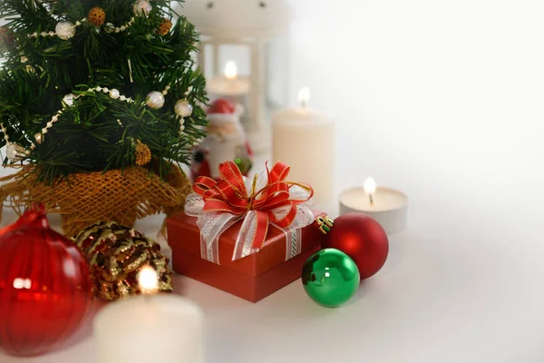 Hediye, yılbaşı ağacı, süs eşyaları ve boşluk beyaz mumlar ile şenlikli Noel süsleri