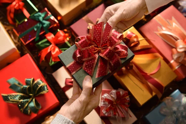 Las personas que dan regalos unos a otros en Navidad y Año Nuevo Festivales con cajas de regalos en el fondo —  Fotos de Stock