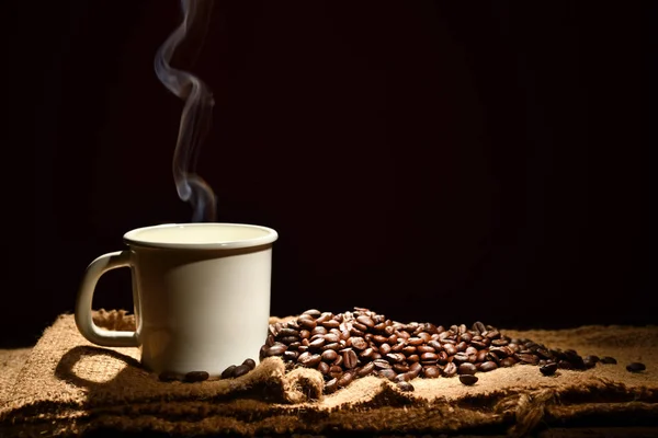 杯咖啡加上黑色背景的烟雾和咖啡豆 — 图库照片