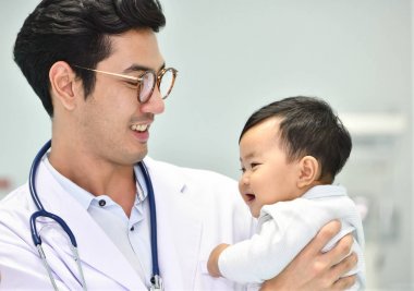 Asyalı çocuk doktoru bebek hastanede ilgileniyor