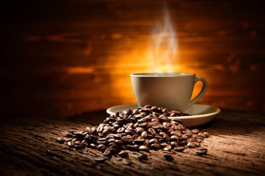 Cup of coffee with smoke and coffee beans on old wooden background clipart