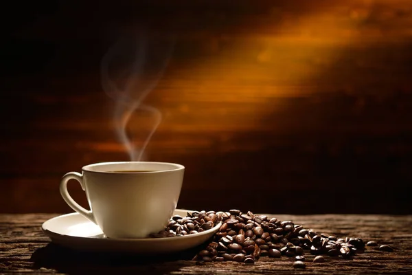 古い木の背景にコーヒーカップとコーヒー豆 — ストック写真