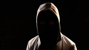 Kapüşonlu siyah arka plan üzerine olan gizemli adam