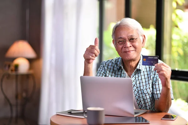 Asian senior man using credit card for online shopping