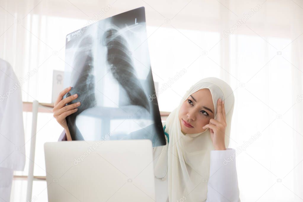 Muslim woman medical doctor looking at x-rays result in a hospital