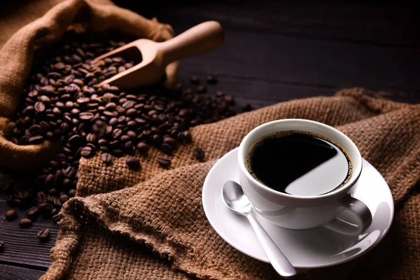 咖啡和咖啡豆放在旧木制背景的麻袋里 — 图库照片