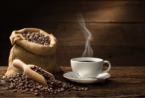 Tasse Kaffee Mit Rauch Und Kaffeebohnen Auf Altem Holzgrund — Stockfoto