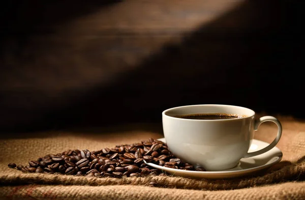 Tasse Kaffee Und Kaffeebohnen Auf Kleesack Auf Altem Holzgrund — Stockfoto