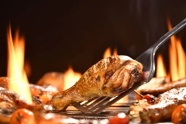 烤鸡腿和各种蔬菜在燃烧的烤架上 — 图库照片