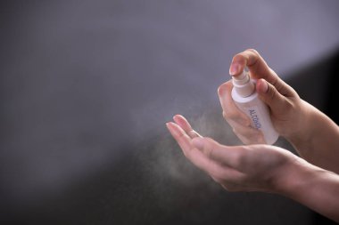 Covid-19 ve diğer hastalıklara karşı dezenfekte ve koruma için el dezenfektanı sıkan eller