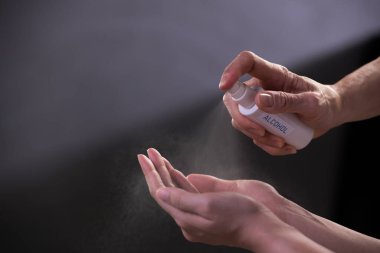 Covid-19 ve diğer hastalıklara karşı dezenfekte ve koruma için el dezenfektanı sıkan eller