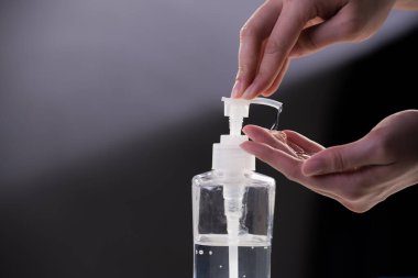 Dezenfeksiyon hijyeni ve Covid-19 ve diğer hastalıklara karşı korunma için alkol jeliyle ellerini yıkayan kişi