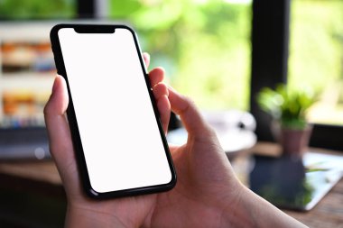 Kafede beyaz ekranlı akıllı telefon kullanan kadınların yakın plan görüntüsü.