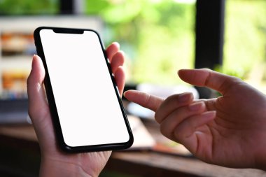 Kafede beyaz ekranlı akıllı telefon kullanan kadınların yakın plan görüntüsü.