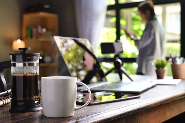 Een Koffiepers Een Kopje Een Bureau Met Een Thuiswerkend Persoon — Stockfoto