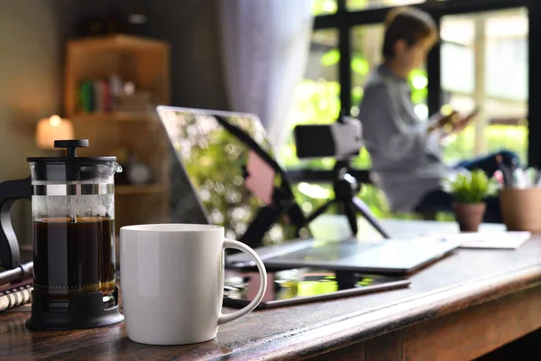 Een Koffiepers Een Kopje Een Bureau Met Een Thuiswerkend Persoon — Stockfoto