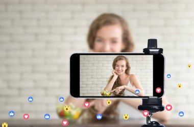 Genç kadın blogcu, vlogger ve çevrimiçi etkileyicisi akıllı telefon kullanarak sosyal medyada canlı yayın yapıyor.