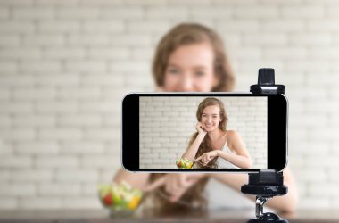 Genç kadın blogcu, vlogger ve çevrimiçi etkileyicisi akıllı telefon kullanarak sosyal medyada canlı yayın yapıyor.