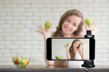 Genç kadın blogcu, vlogger ve çevrimiçi etkileyicisi akıllı telefon kullanarak sosyal medyada canlı yayın yapıyor.