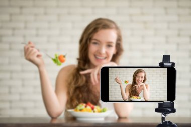 Genç kadın blogcu, vlogger ve çevrimiçi etkileyicisi akıllı telefon kullanarak sosyal medyada canlı yayın yapıyor.