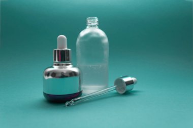 Zümrüt zümrüt zemininde cam pipetli lüks kozmetik şişesi ve mesaj için yer. - Bakuchiol konsepti. Retinol alternatifi.