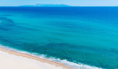 Kumlu sahil ve turkuaz mavi deniz manzaralı..