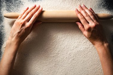 Düz kadın eli ve unlu merdane. Ekmek yapma konsepti. Glütensiz sağlıklı diyet. Boşluğu kopyala.