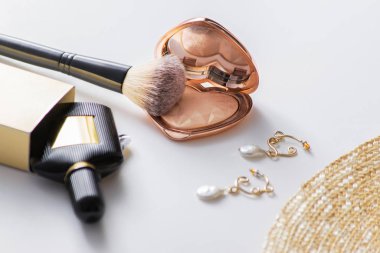 Allık, fırça ve hasır şapkalı küpeler.