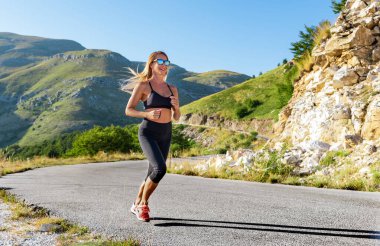 Genç aktif kadın dağlarda egzersiz yapıyor.