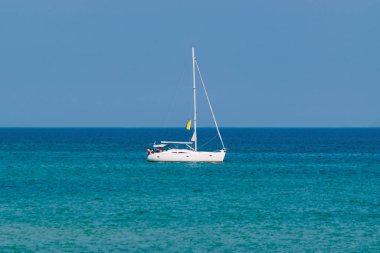 Lüks beyaz yelkenli yatı gün içinde sakin mavi denizde yüzüyor. - Uzay metniyle lüks yelken konsepti.