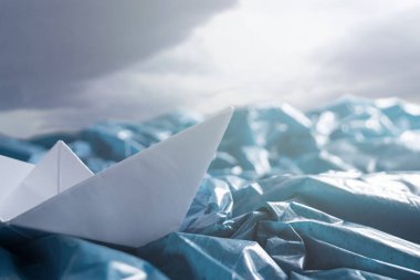 Plastikle okyanus kirliliği kavramı. Fırtınada kağıttan gemiler