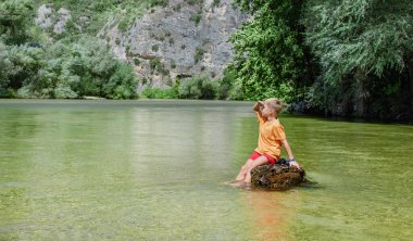 Yazın nehirde dinlenen tatlı sarışın çocuk.