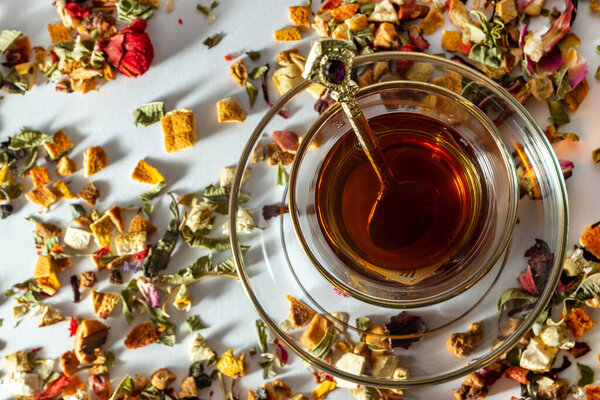 Плоская укладка традиционного арабского восхитительного чая в стеклянной чашке и золотой ложке. Смешанные сухие травы и цветы зеленого чая. Белый фон, горизонтальный. Арабский традиционный чай класса люкс
.