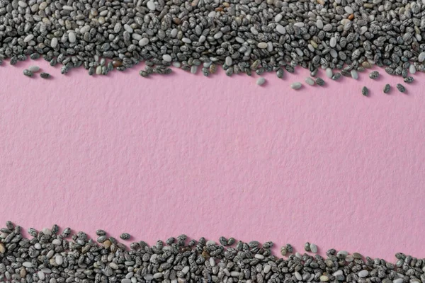 Suche nasiona chia na różowej powierzchni z miejsca do kopiowania. Superfood makieta koncepcja, płaskie układanie. — Zdjęcie stockowe
