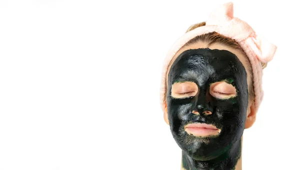 Yüzü koyu renk cilt maskeli bir kadın. İzole edilmiş, beyaz arkaplan, kopyalama alanı. Cilt spa tedavisi kavramı.